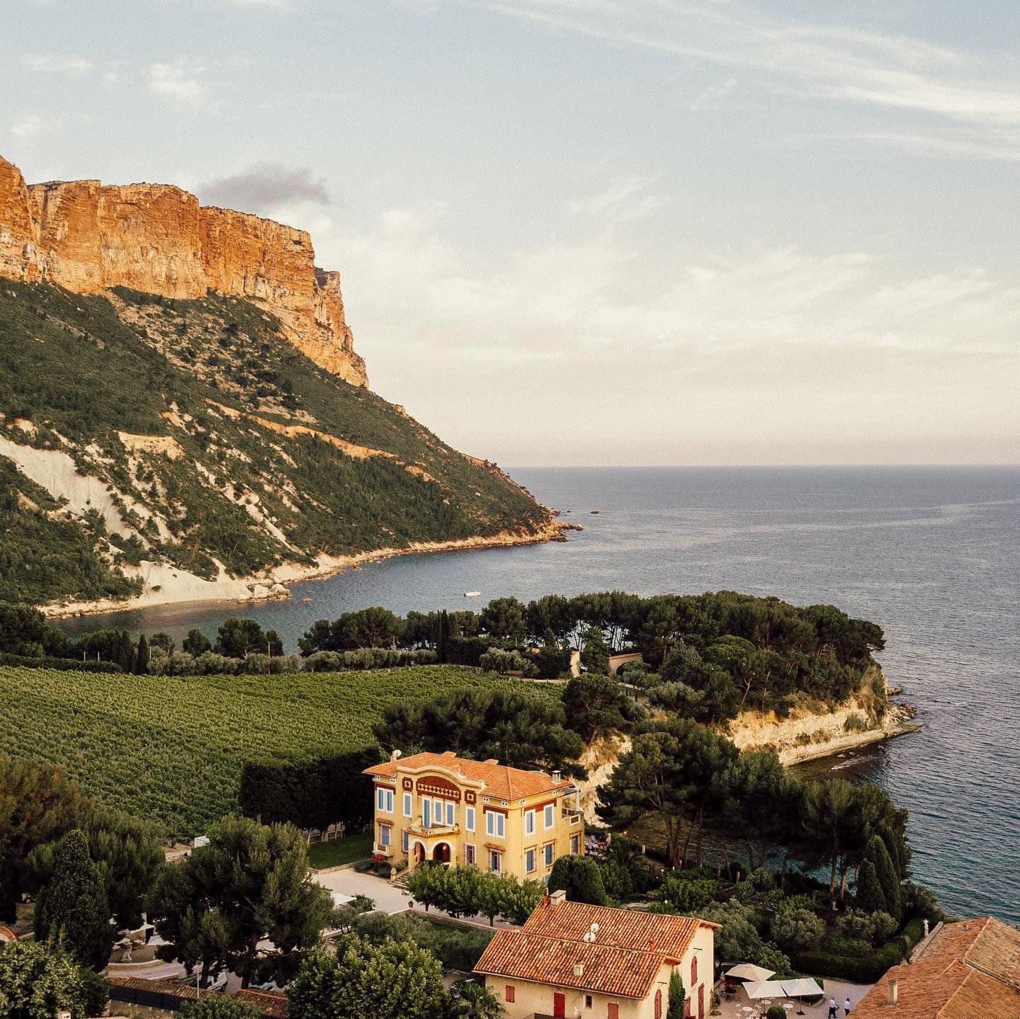 Coastal villa perched on Mediterranean cliffs of Cassis France with red-tiled roofs and dramatic seaside views.