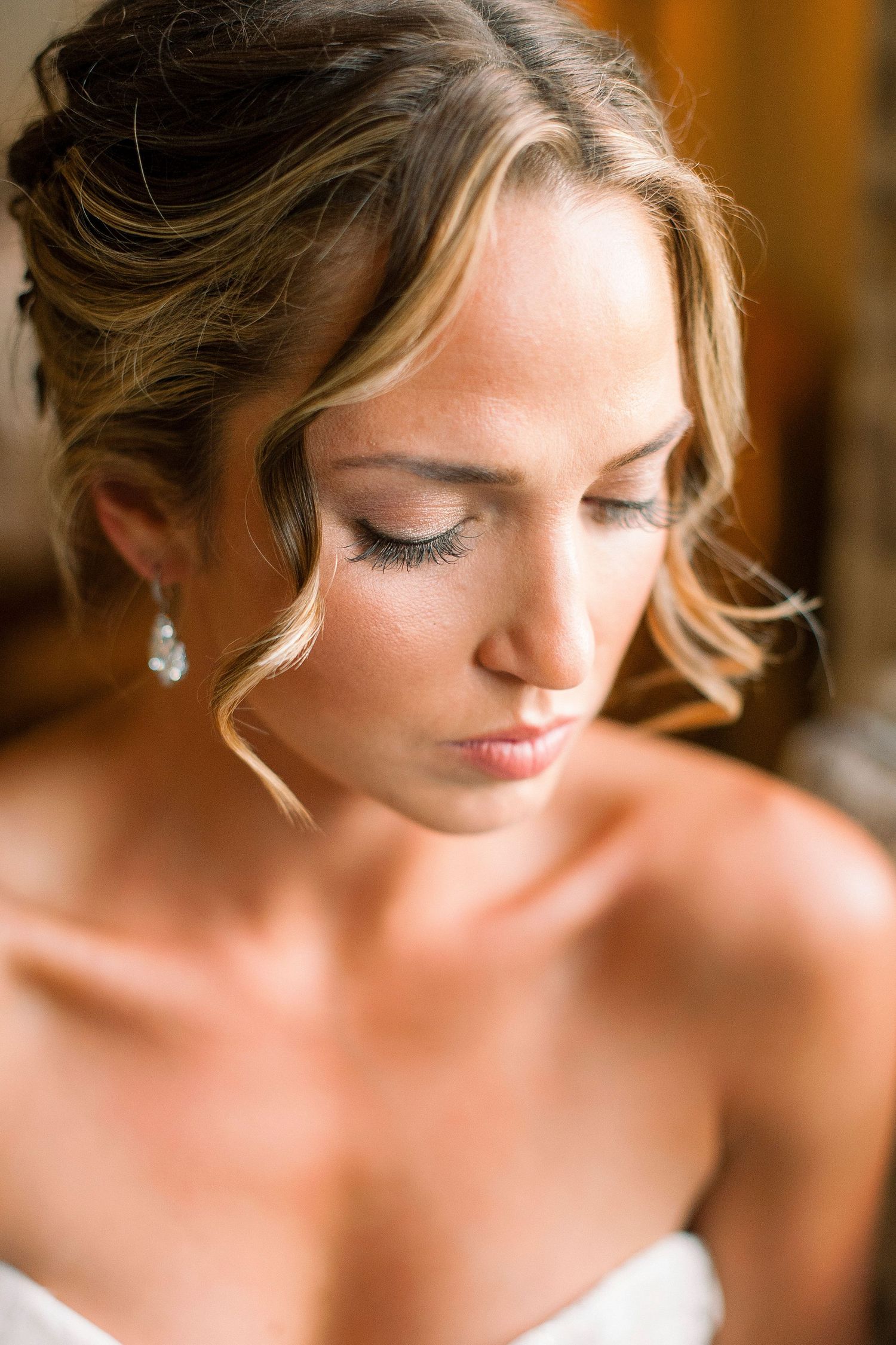 Close-up beauty shots of a bride with elegant updo hairstyle and soft makeup on her wedding day.