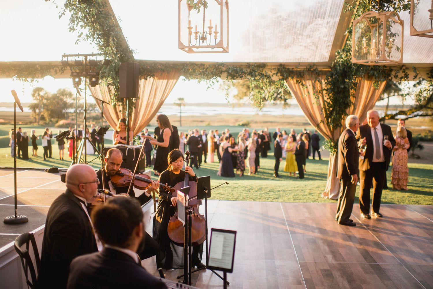 Musicians perform at an elegant wedding reception in a venue with large windows overlooking a scenic landscape.