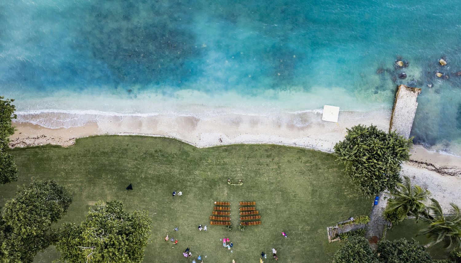 Aerial panoramic view of a tropical coastline with turquoise waters, green cliffs and sandy beaches.