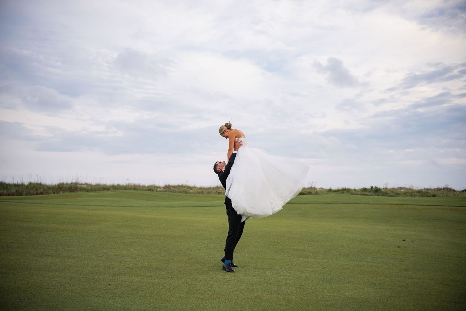 Sequence of jumping photos on a green golf course against cloudy sky.