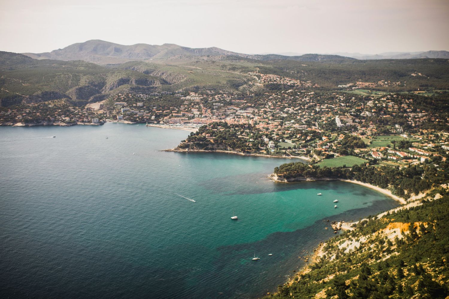 Aerial view of a coastal Mediterranean town in Cassis France nestled in a bay with turquoise waters.