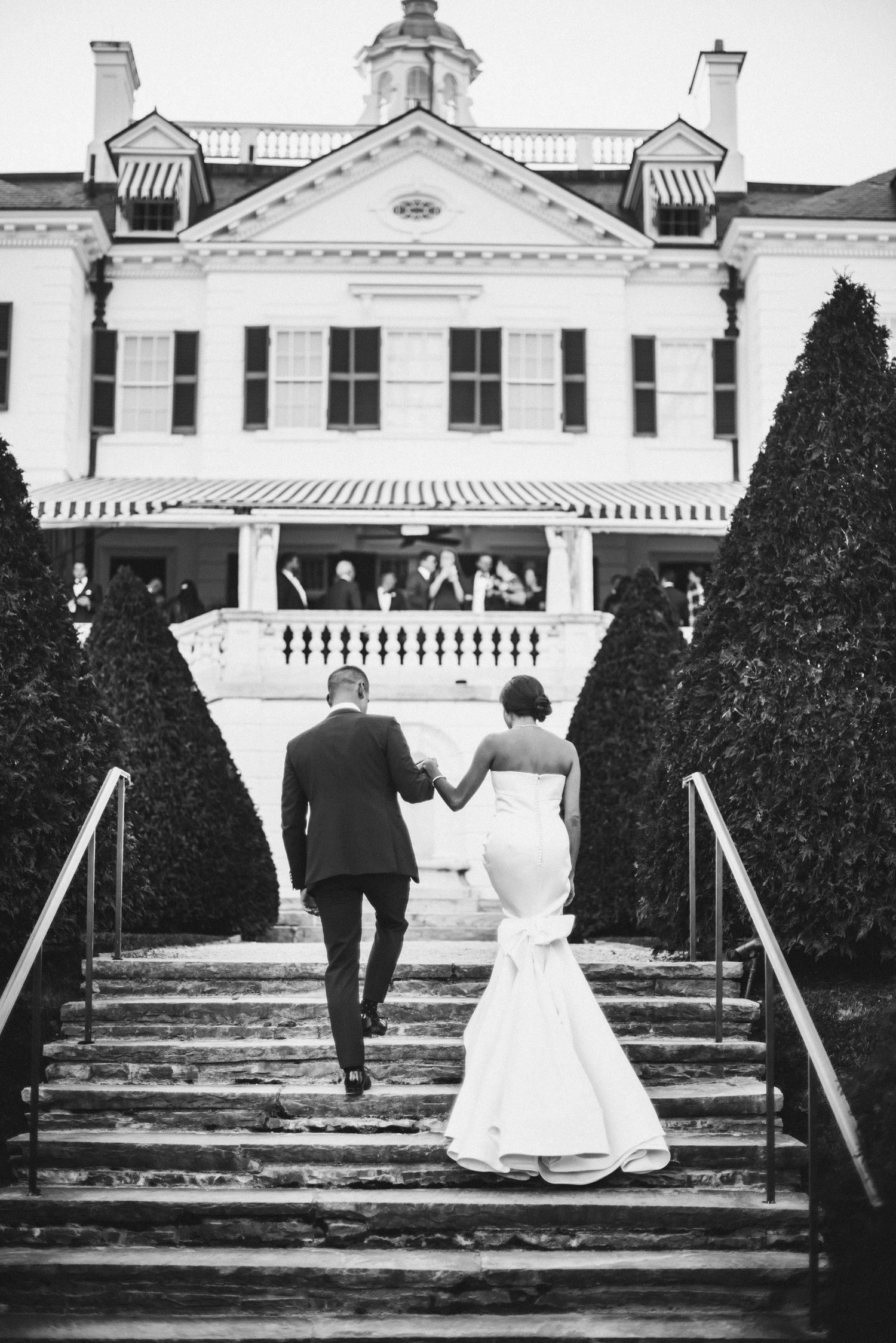Black and white photo sequence showing a couple ascending grand steps towards an elegant mansion with white columns.