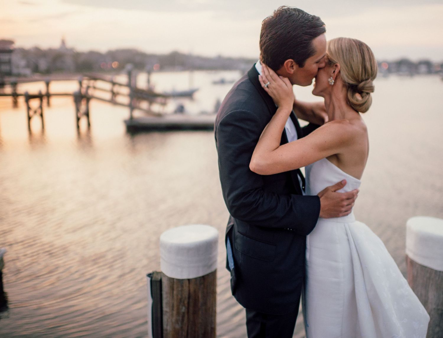 Romantic couple sharing intimate moments by the waterfront during golden hour.