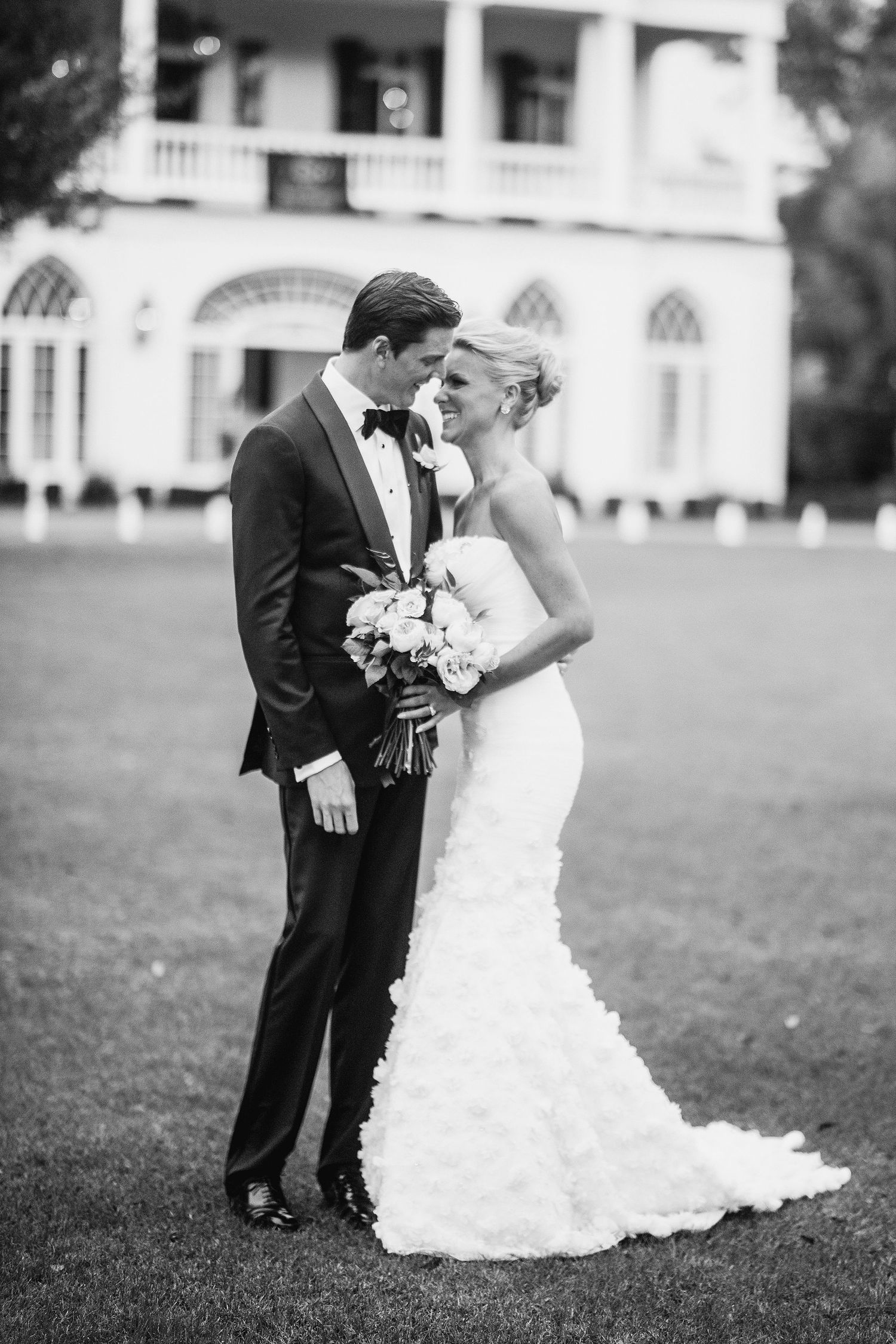 Romantic black and white wedding photos showing couple embracing on grassy lawn.