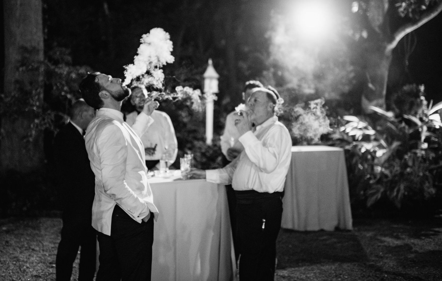 A series of black and white wedding photos showing couples dancing and celebrating at an outdoor evening reception.