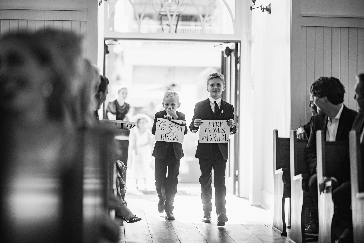 A series of black and white wedding photographs arranged in a filmstrip style showing candid moments during the ceremony.
