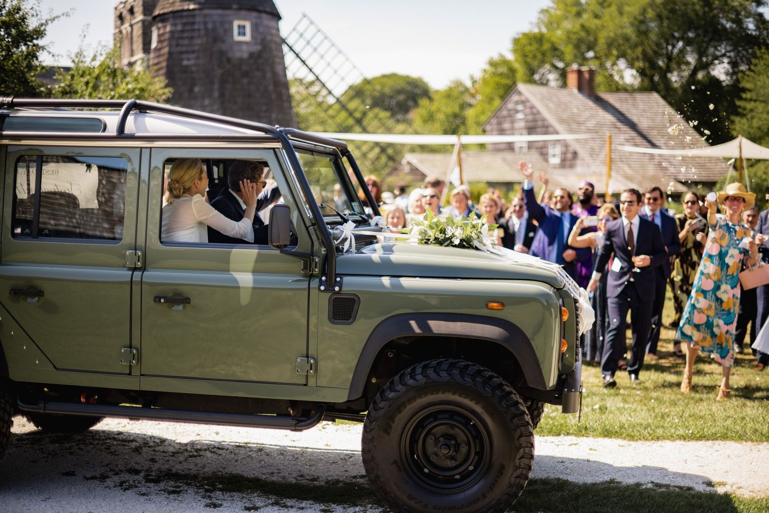 A military-style Hummer vehicle shown from multiple angles at an outdoor event with spectators and greenery.