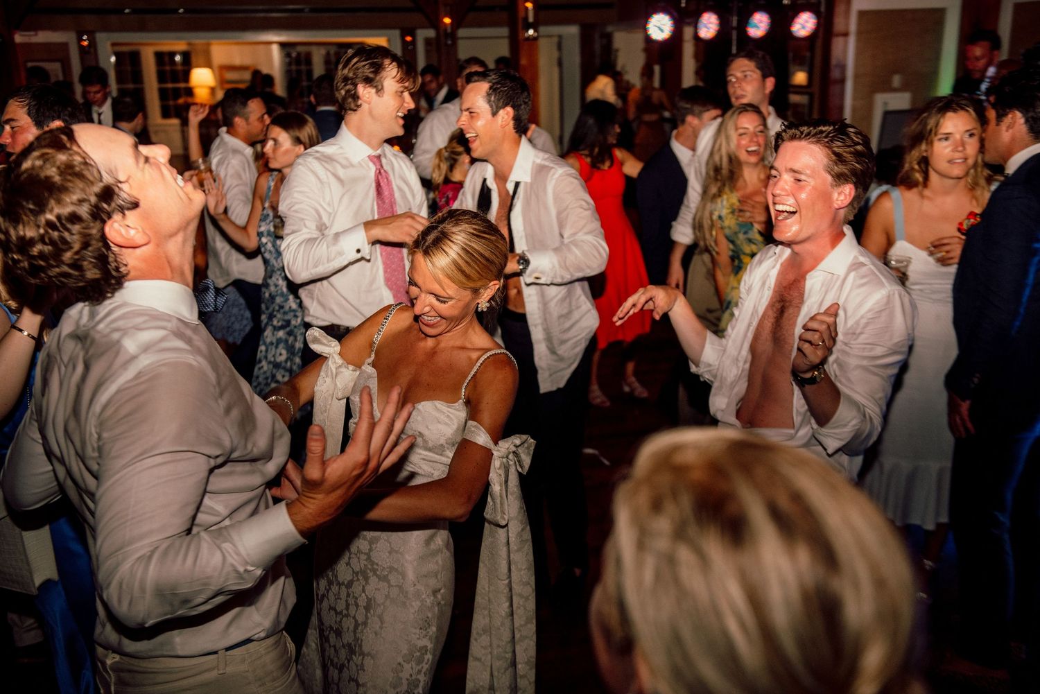 Lively dance floor scene with guests enjoying themselves at an evening wedding reception.