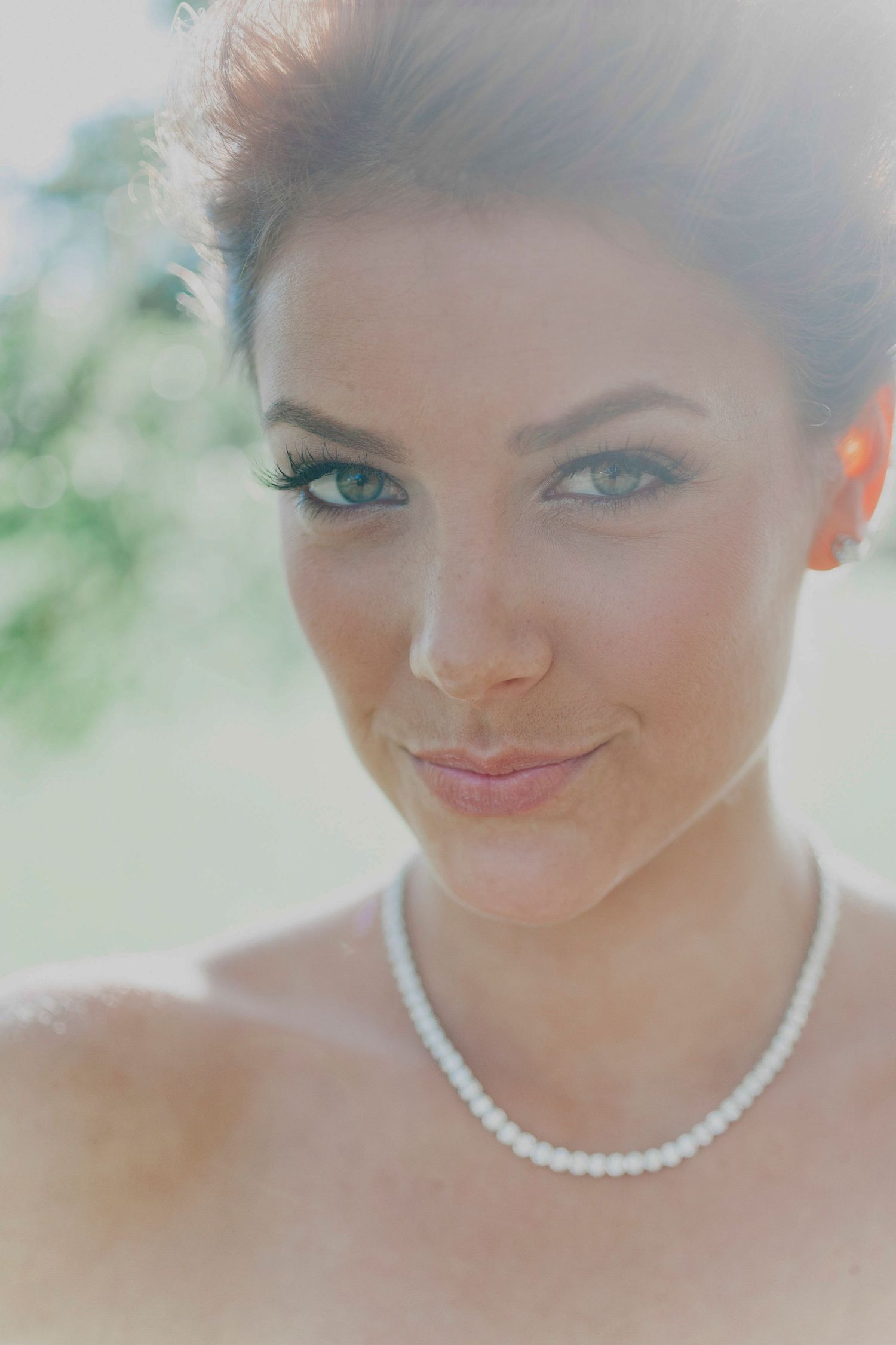 Close-up bridal portrait showing pearl necklace and soft makeup.