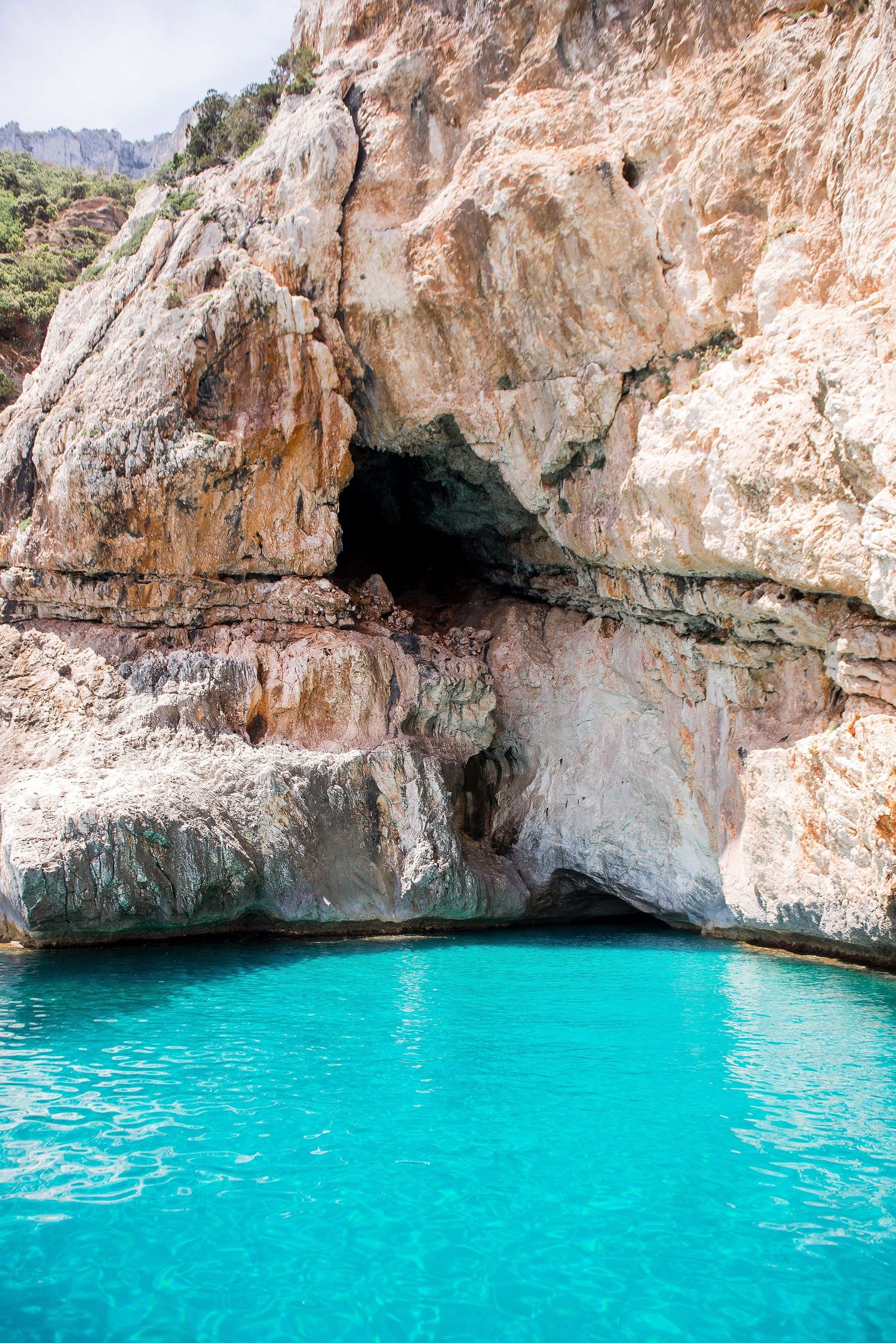 Crystal clear turquoise waters in a natural sea cave with limestone rock formations.