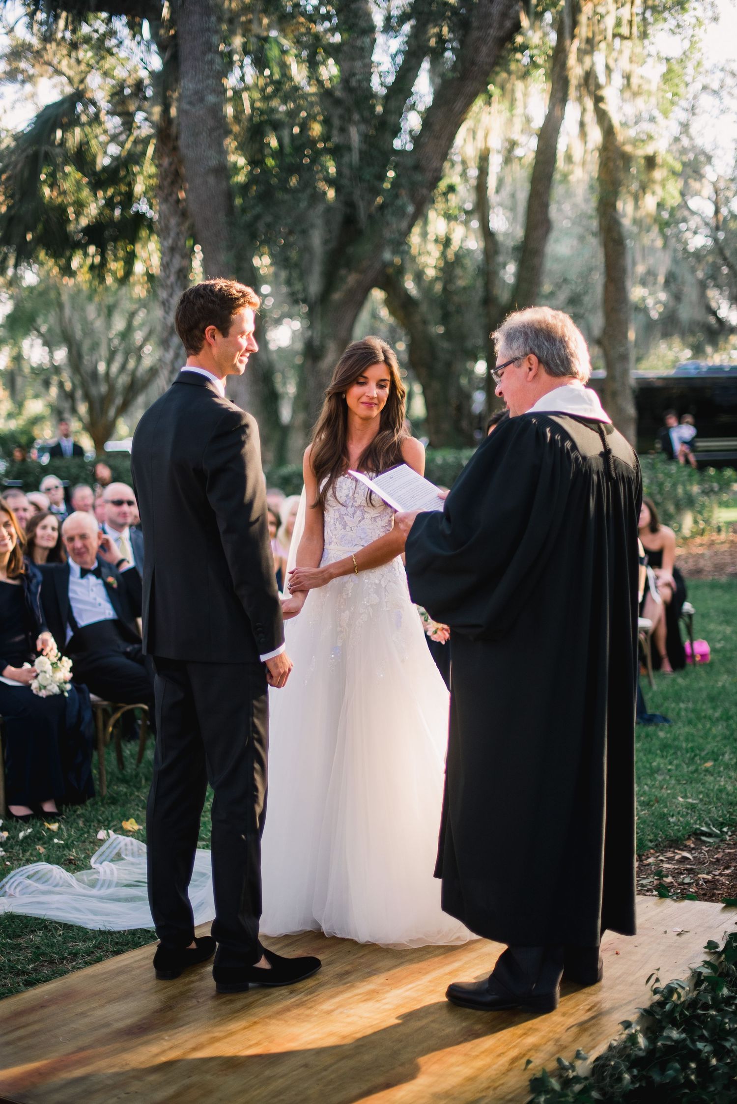 A series of candid wedding photos showing guests and wedding party members gathered outdoors in a wooded setting.