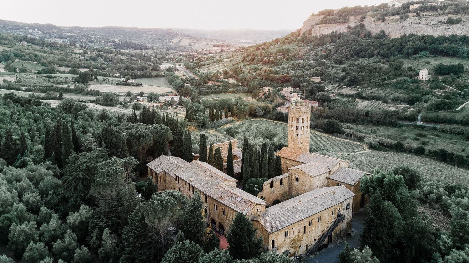 Panoramic view of an ancient hillside monastery in Orvieto with stone buildings and Mediterranean architecture.