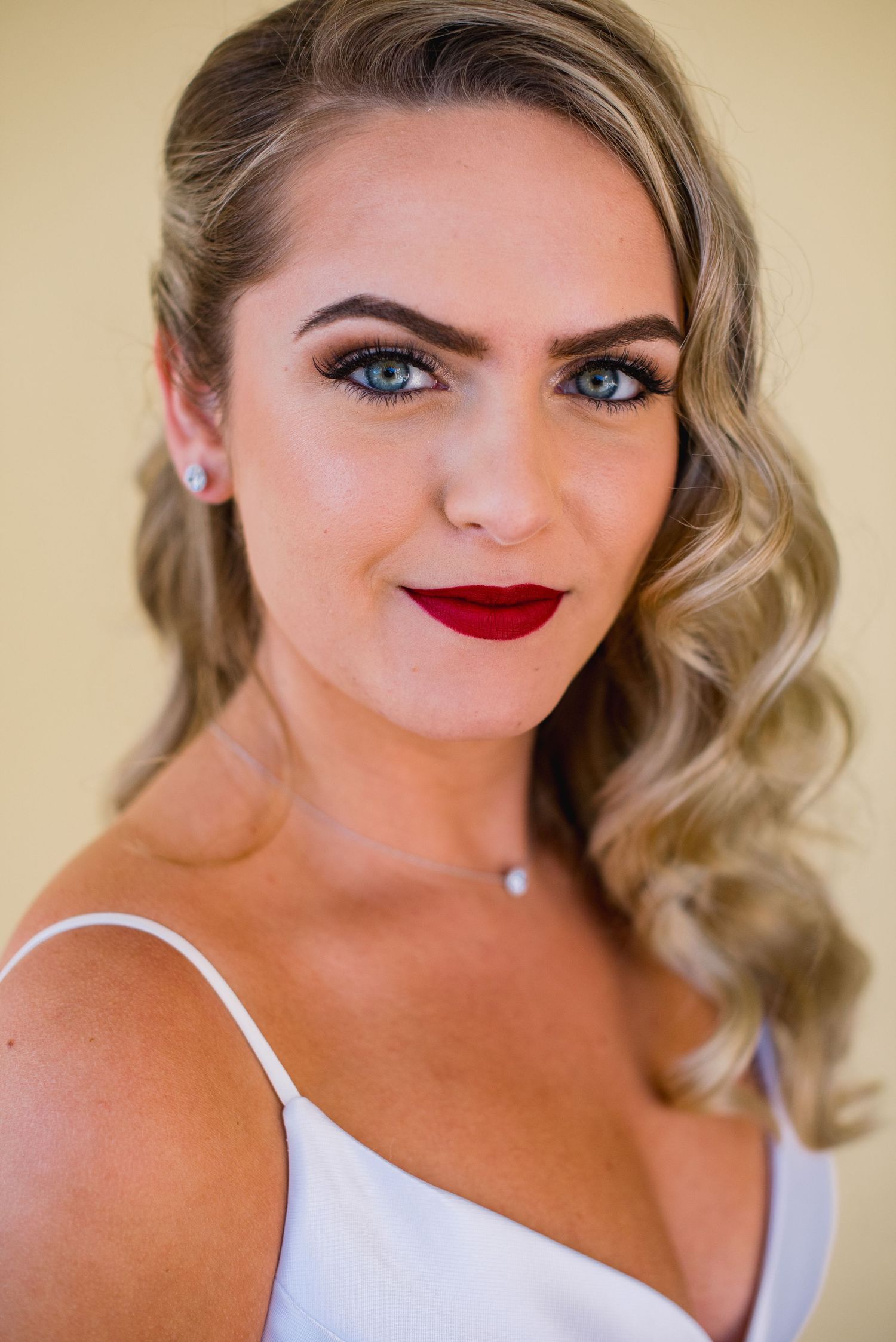A series of glamorous bridal portraits showing elegant blonde wavy hair, red lipstick and white dress details.