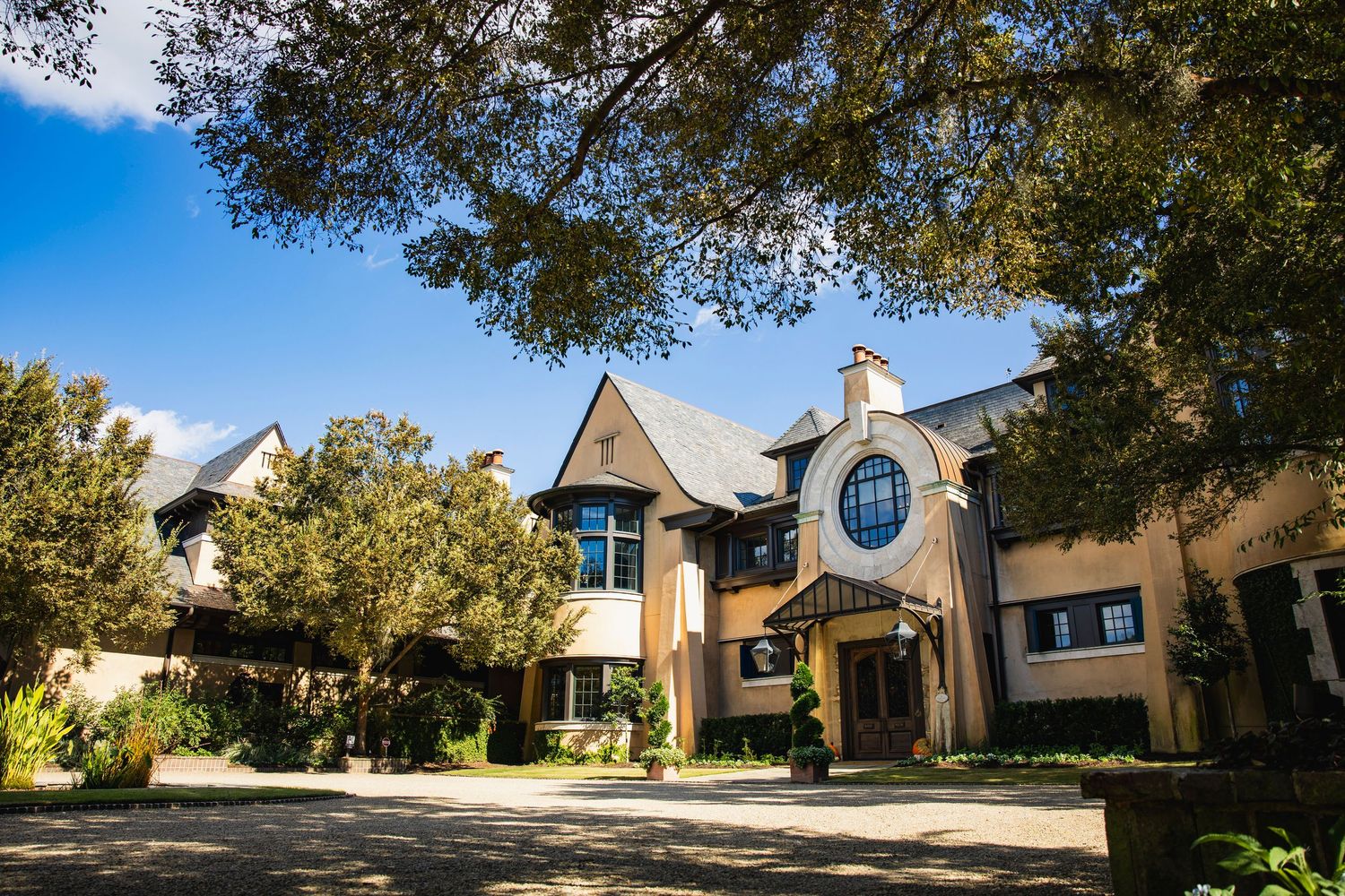 Exterior view of a modern residential neighborhood with Tudor-style homes and well-maintained landscaping on a sunny day.