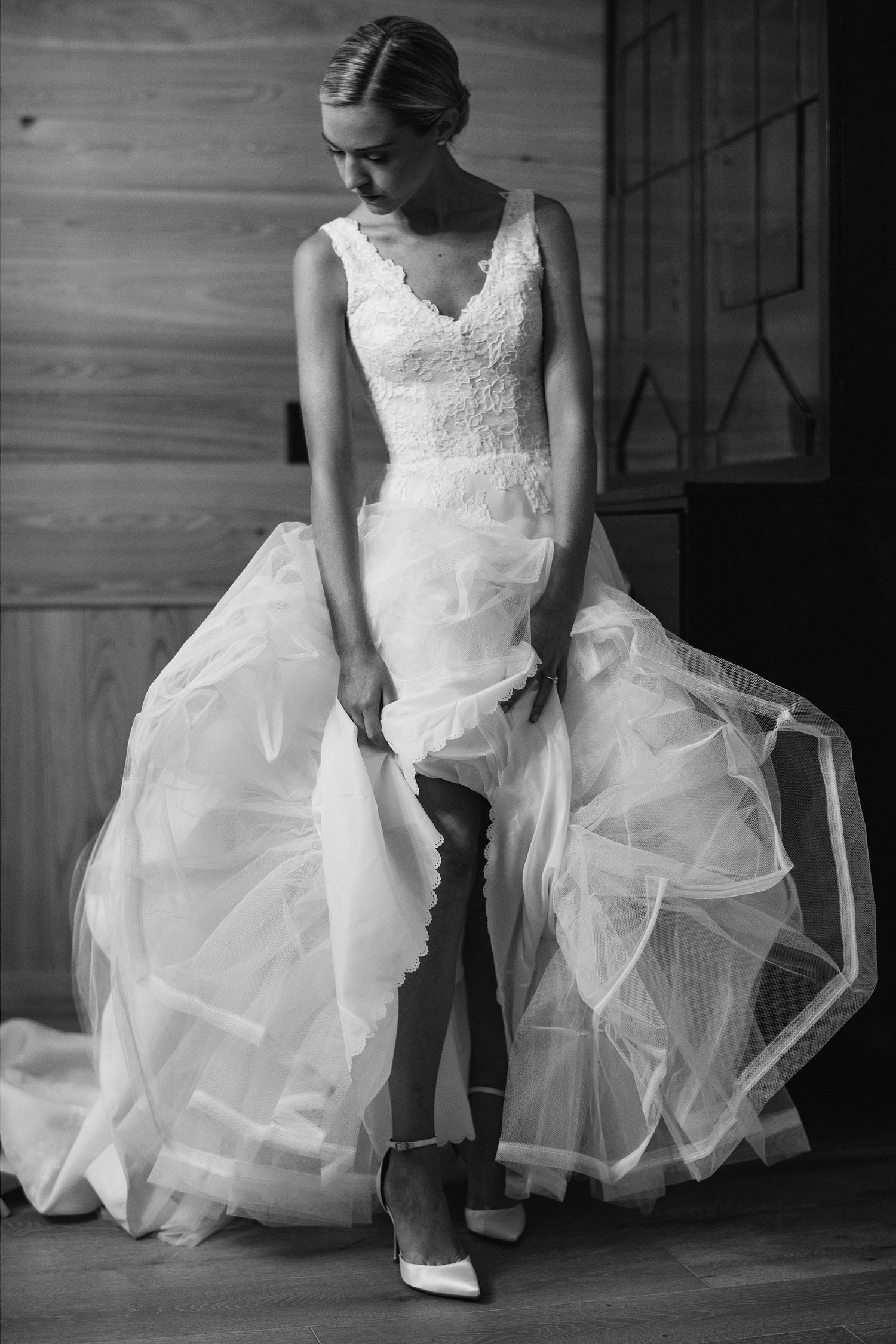 Black and white photos showing details of a layered tulle wedding dress and shoes.
