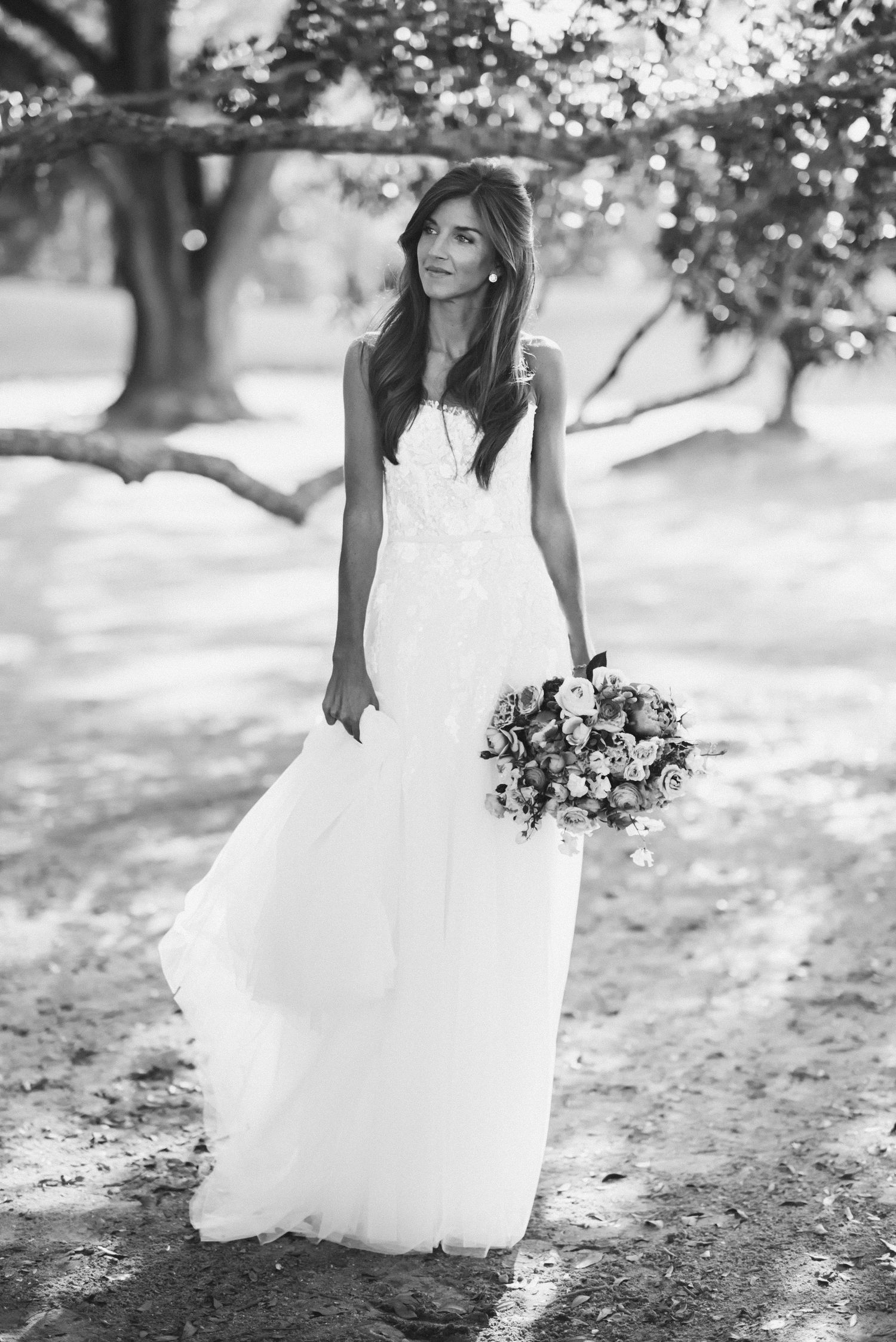 Black and white photo series of a bride in a flowing white wedding gown walking through a garden setting.
