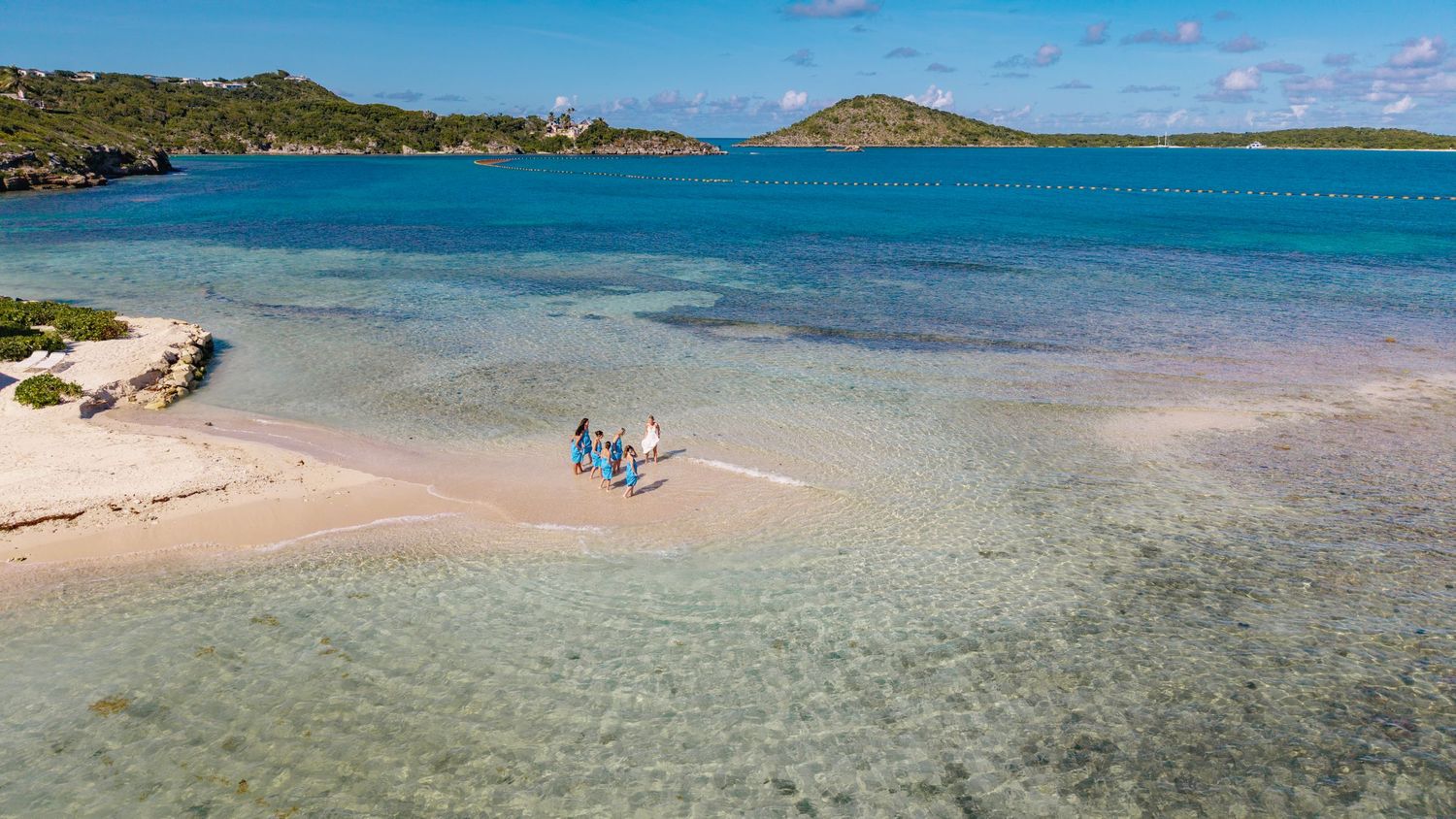 Aerial panorama of a pristine beach coastline with crystal clear turquoise waters and lush vegetation.
