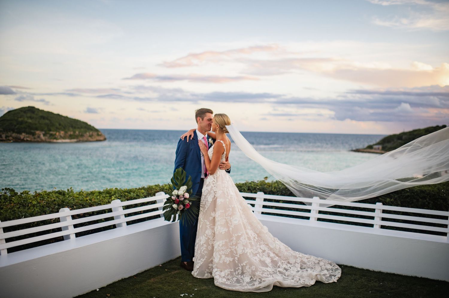 Romantic sunset wedding photos on oceanfront terrace with mountain views.