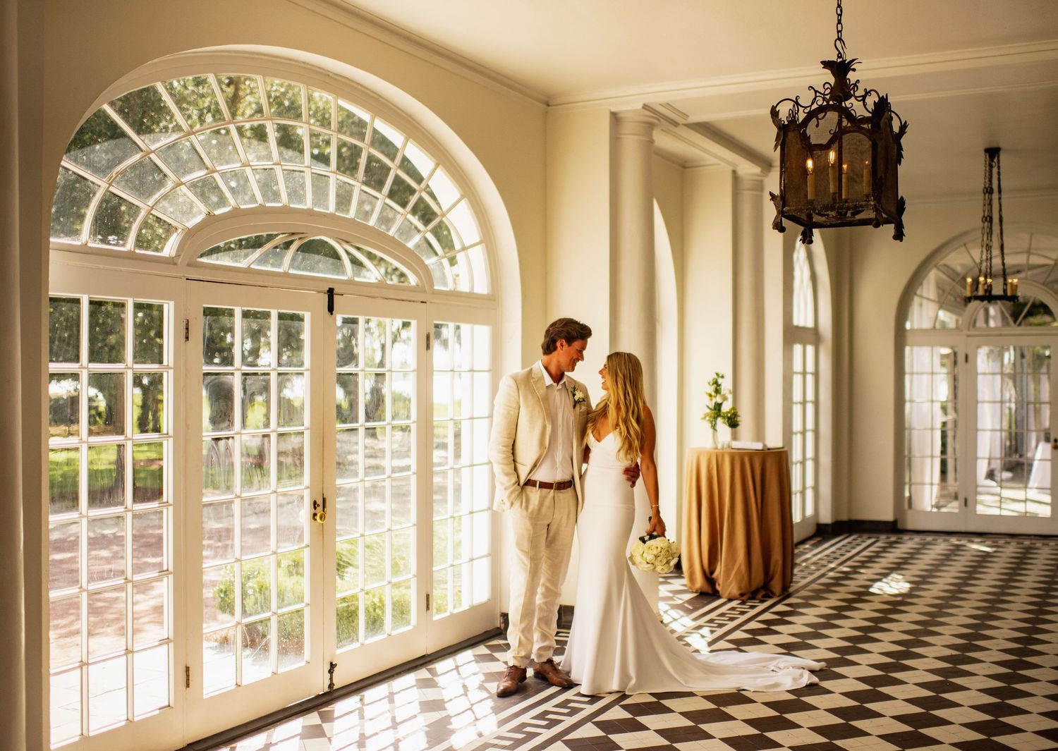 Elegant sunlit conservatory at Lowndes Grove with black and white checkered floor and arched windows creates a bright, sophisticated space.