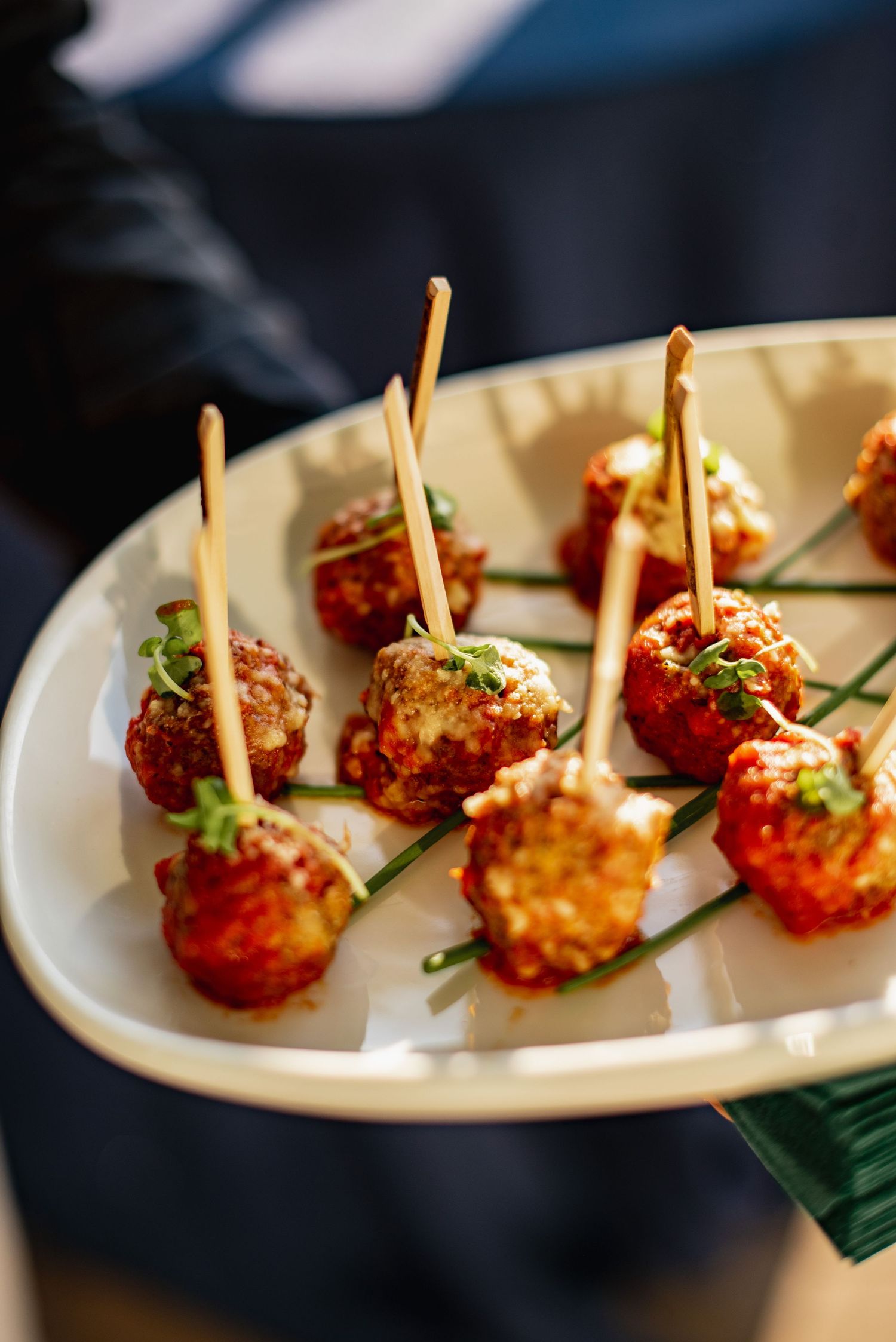 Elegant appetizer plate featuring crispy shrimp lollipops garnished with green herbs on a white serving dish.