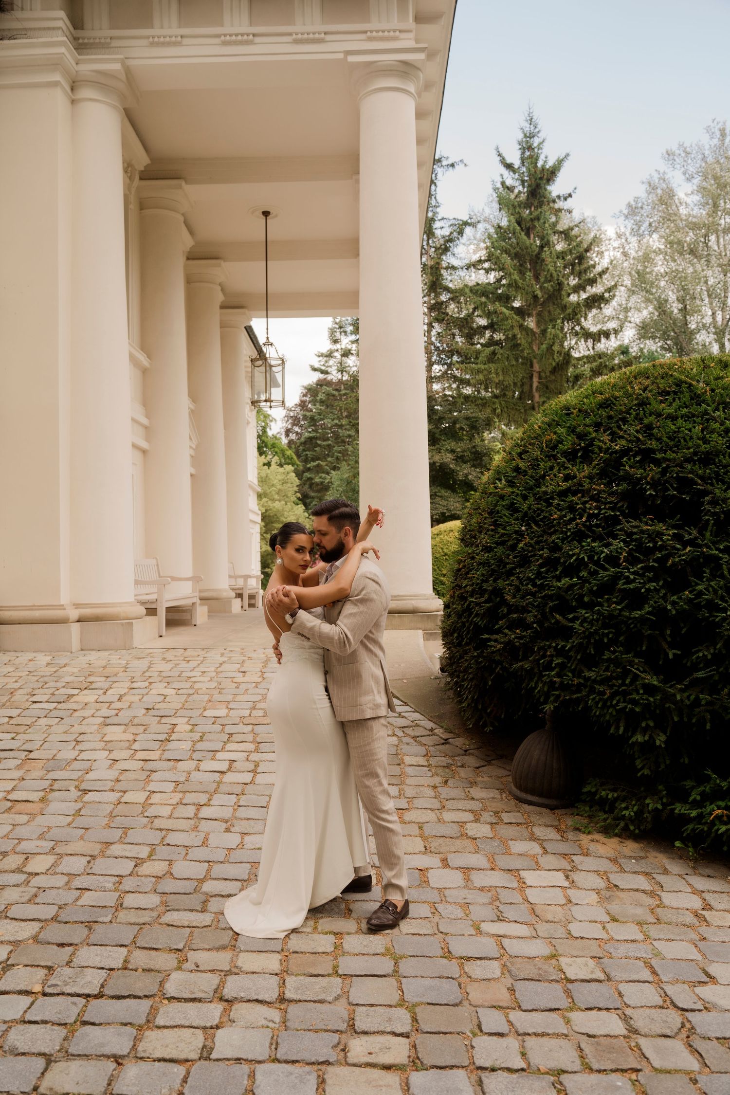 Panna młoda z bukietem przed eleganckim budynkiem