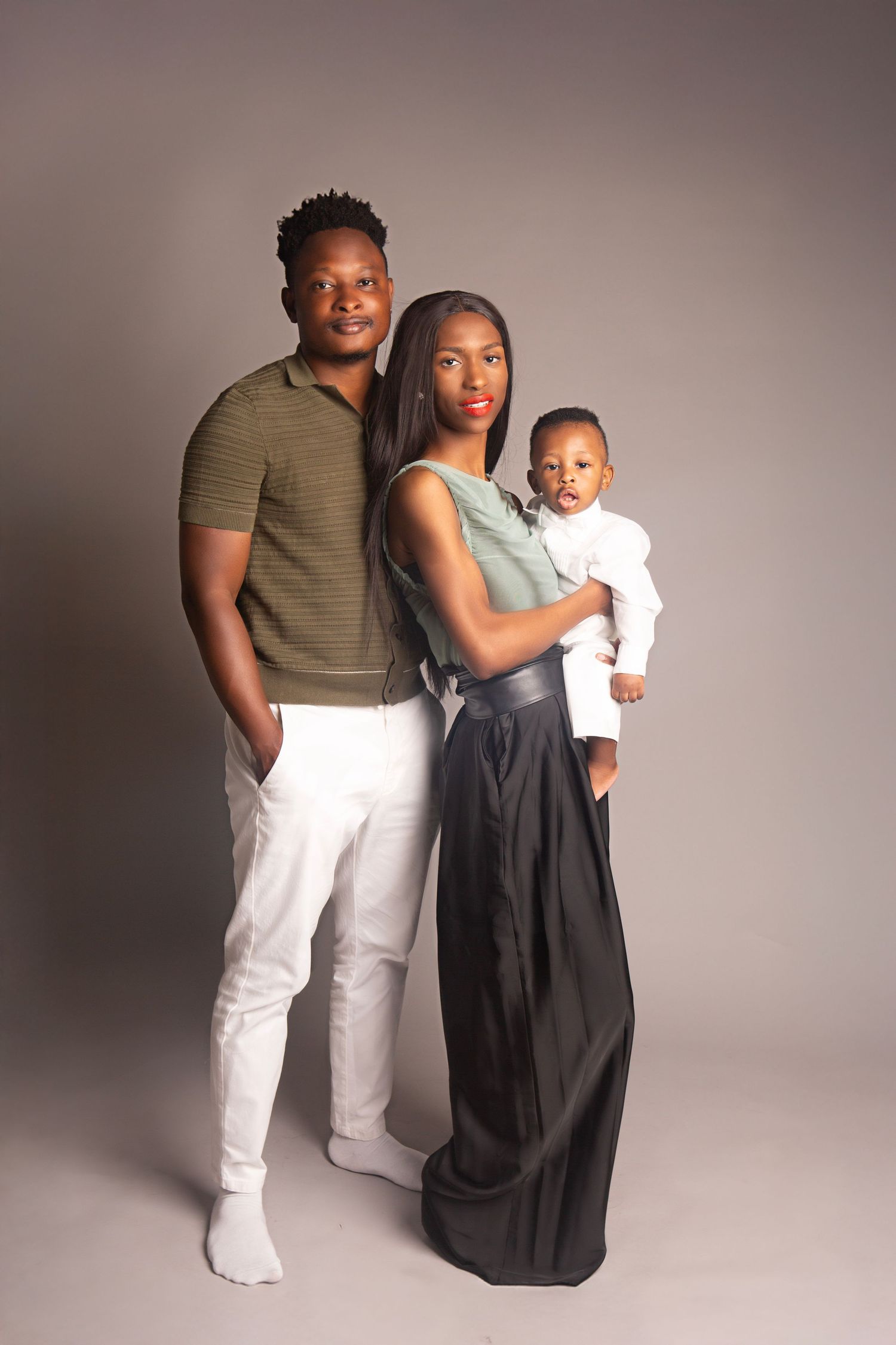 A charming family portrait featuring mum, dad and their stylish one year old, dressed sharp for the occasion.