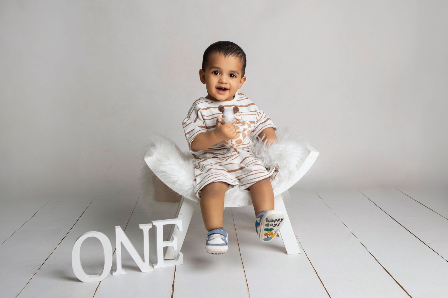 A joyful first birthday cake smash moment, capturing pure delight and personality in this milestone celebration.