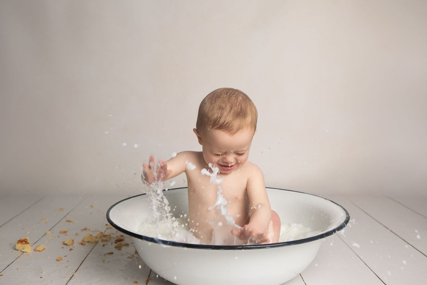A playful first birthday image of boy enjoying bath time, full of giggles, bubbles and joyful splashing.