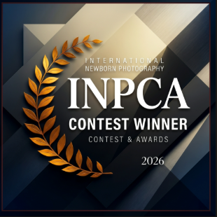 INPCA International Newborn Photography Contest Winner 2026 award badge with gold laurel wreath design.