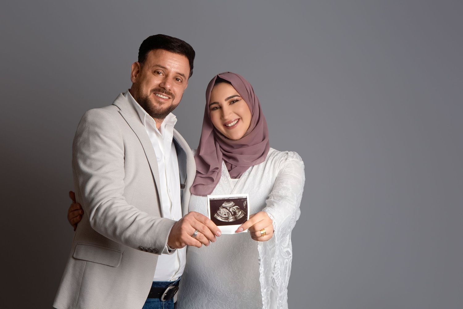 A touching image of mum and dad holding their hospital photo, bridging the journey from bump to baby.
