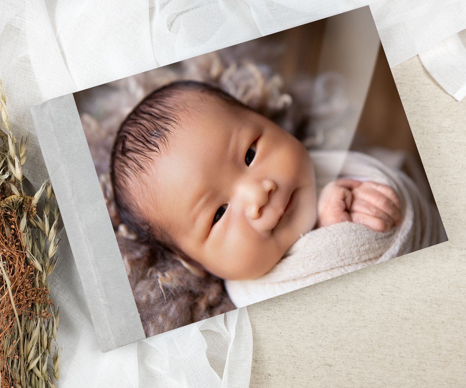 A beautifully personalised album cover featuring baby boy wrapped softly, capturing pure newborn innocence.