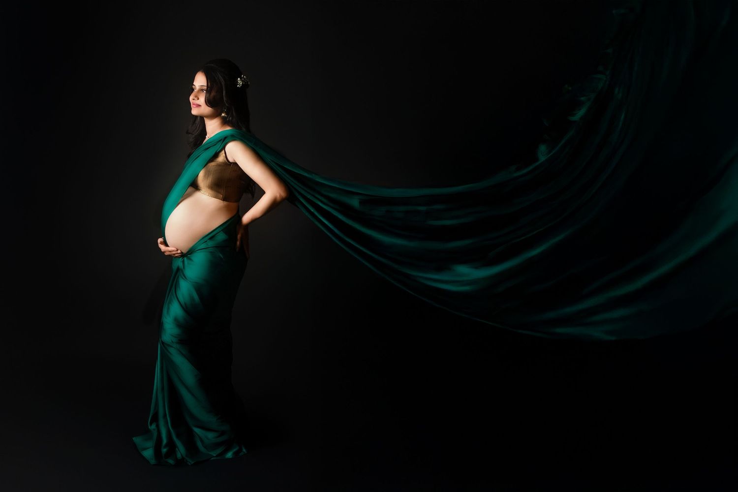A stunning maternity portrait featuring a deep green sari, beautifully celebrating culture, elegance and motherhood.