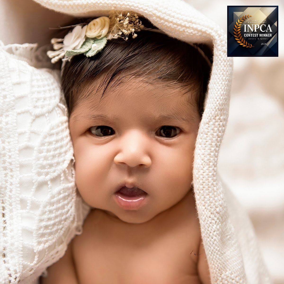 An award winning portrait capturing baby's direct, captivating gaze straight into the camera, full of character.