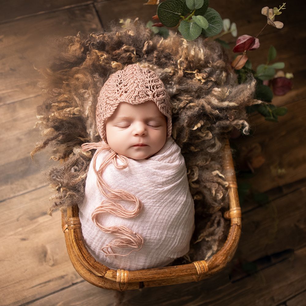 A soft newborn portrait of baby girl wrapped in gentle pink and brown tones, warm and beautifully natural.