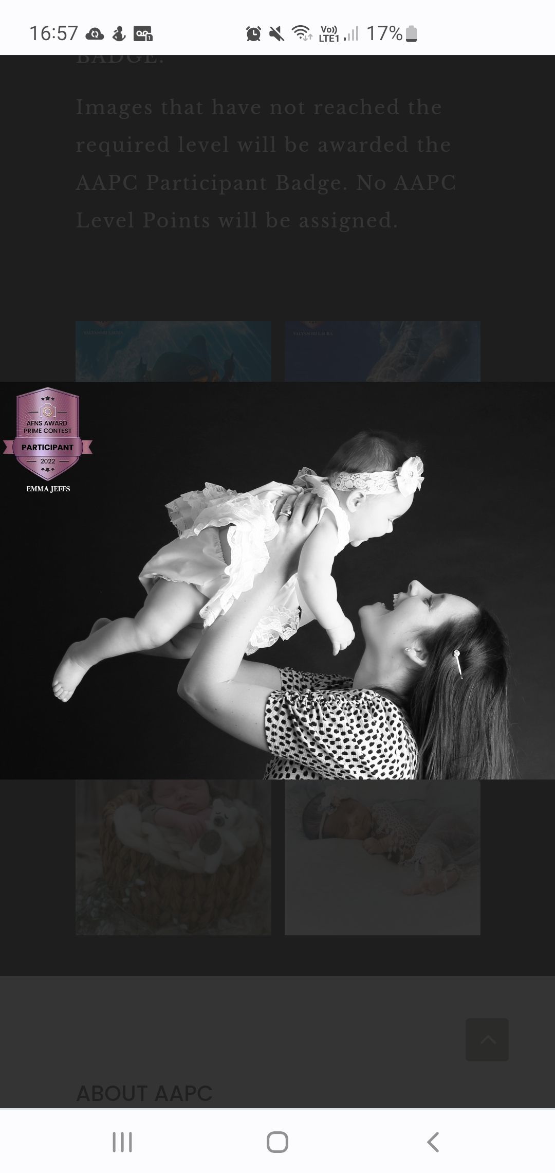 A black and white photo of a mother joyfully lifting her newborn baby overhead in a studio portrait.