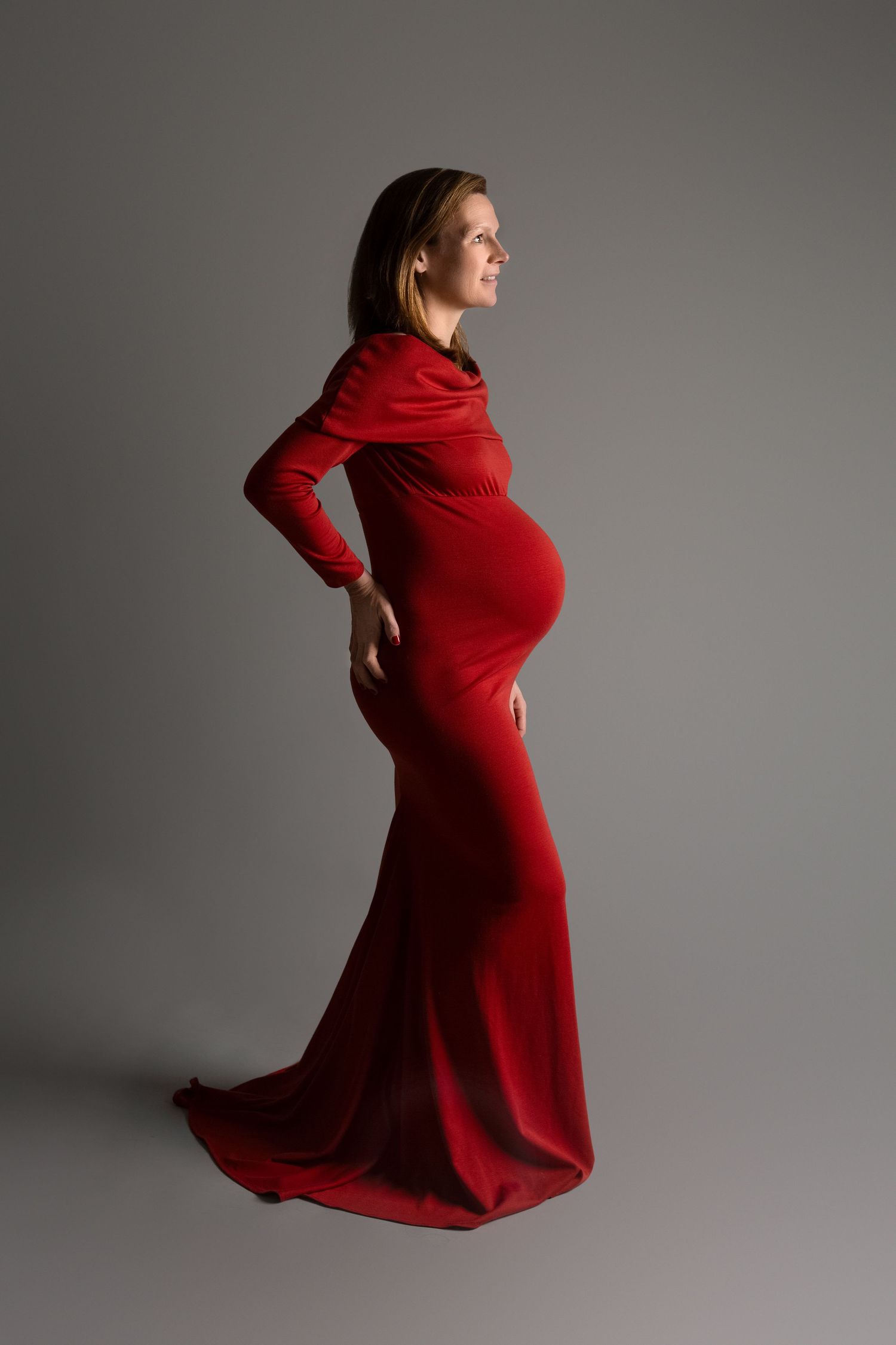 A bold, vogue inspired maternity portrait featuring mum in a striking red dress, full of glamour and confidence.