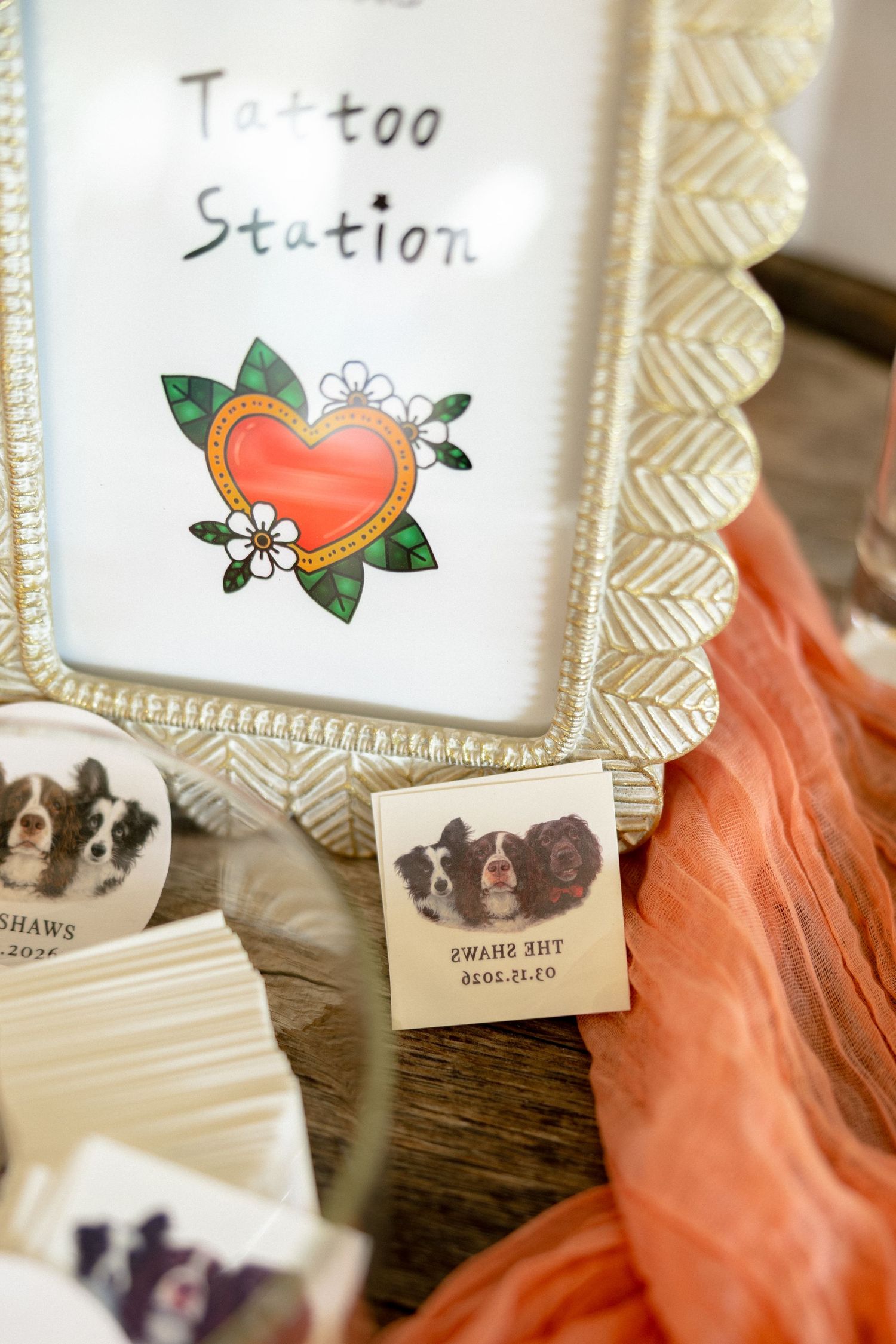 Wedding tattoo station display with dog portrait temporary tattoos and decorative heart illustration sign.