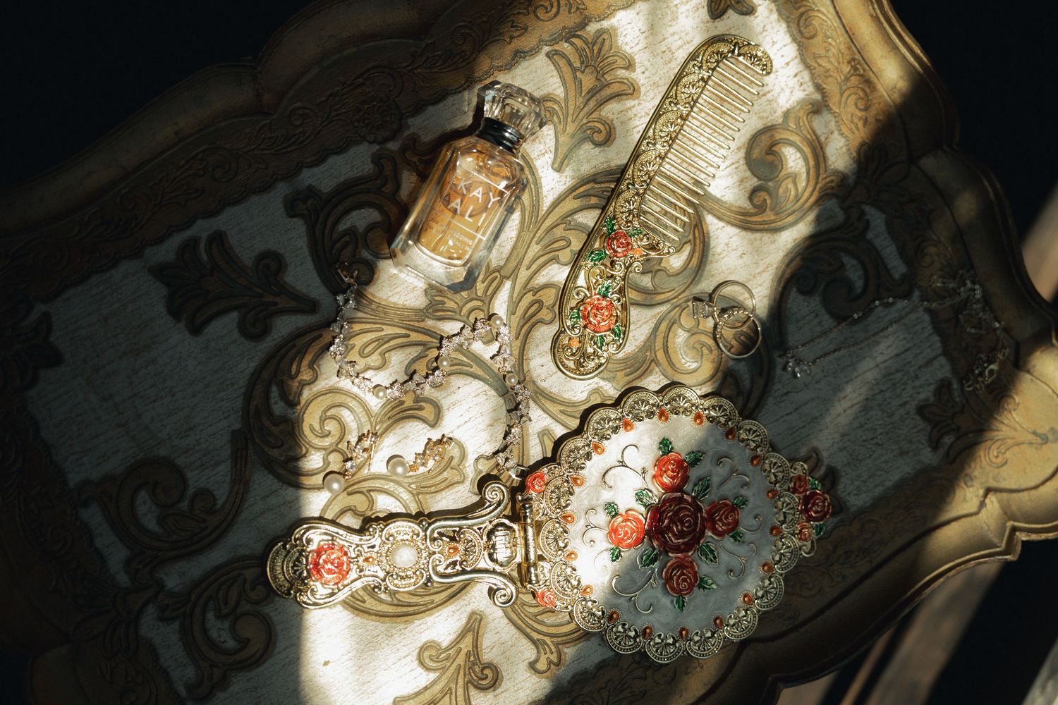 Ornate vintage bridal accessories with floral embroidery and perfume bottle.
