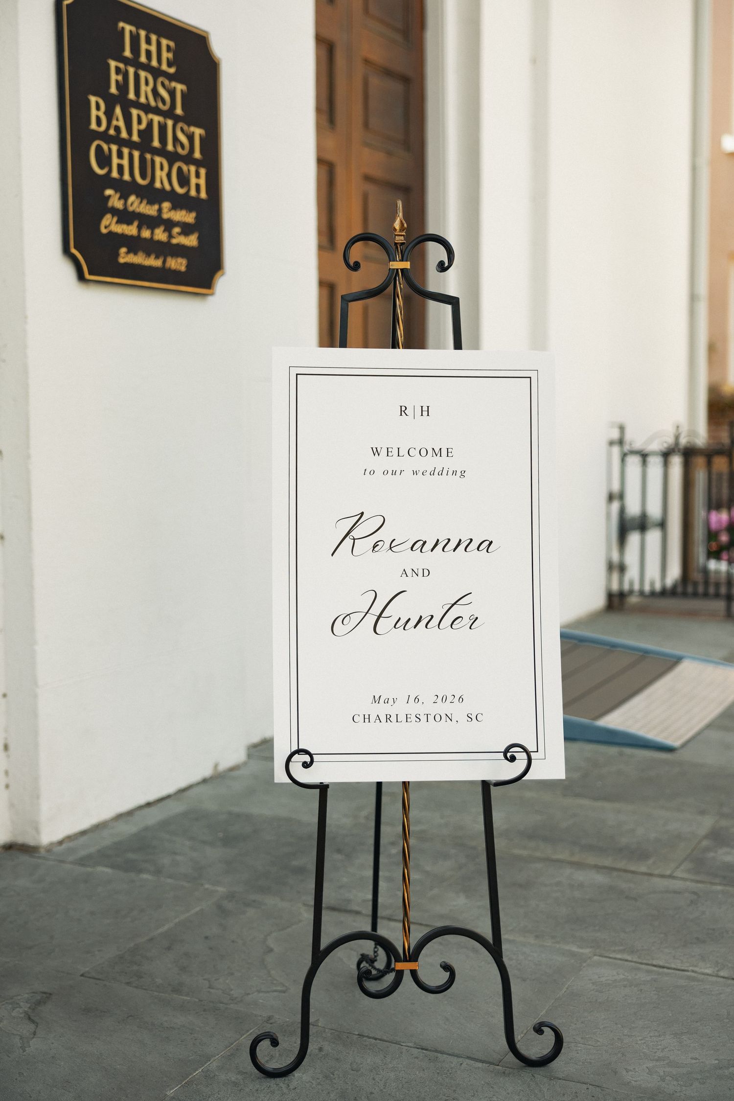 Wedding welcome sign for Rexanna and Hunter on an ornate black easel outside First Baptist Church in Charleston, SC.
