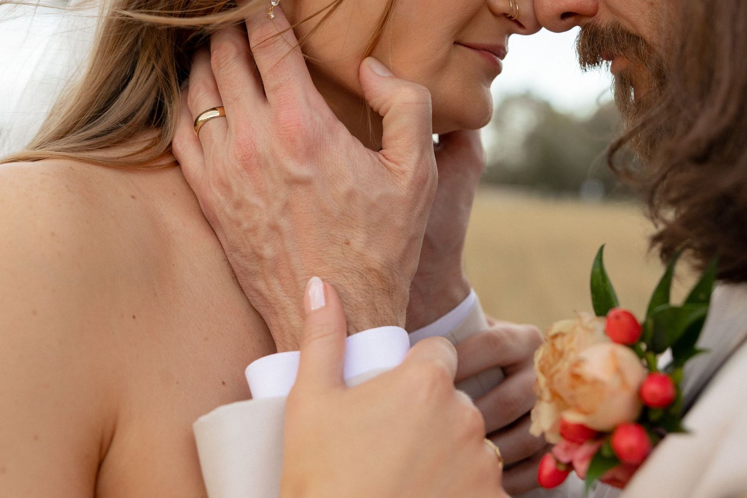 Intimate close-up of bride and groom nearly kissing, groom wearing floral boutonniere.