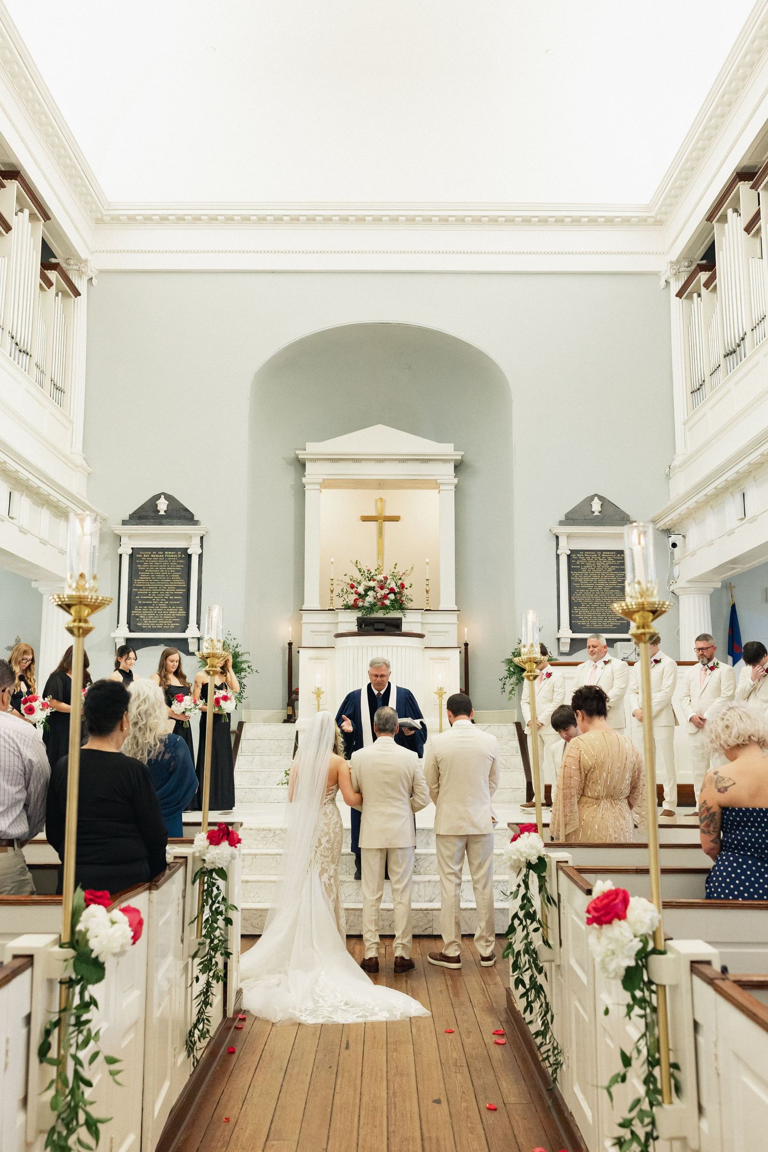 Bride and groom stand at the altar of a historic church during their wedding ceremony.
