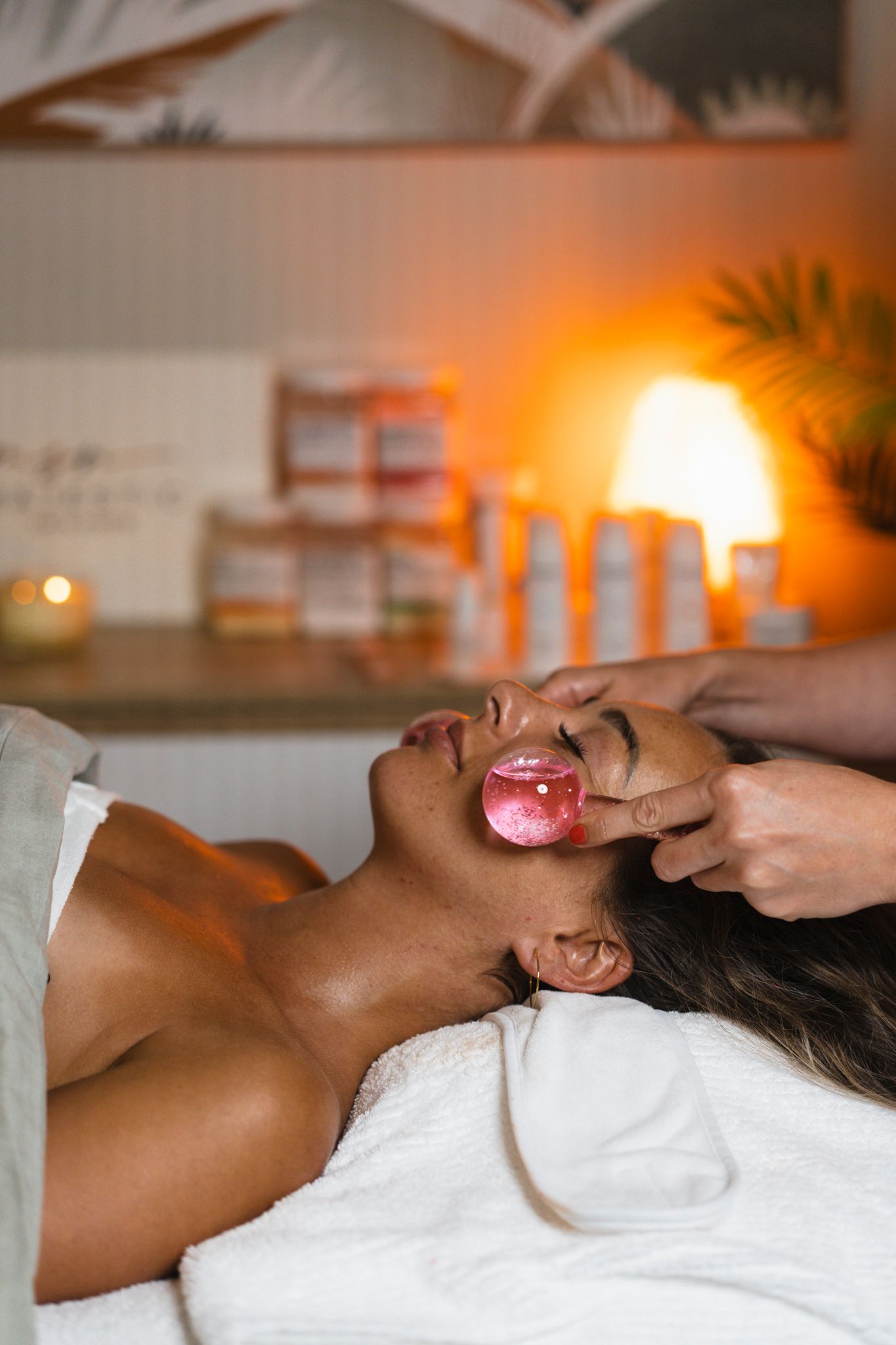 A person receives a relaxing facial treatment at a luxury spa with warm ambient lighting.