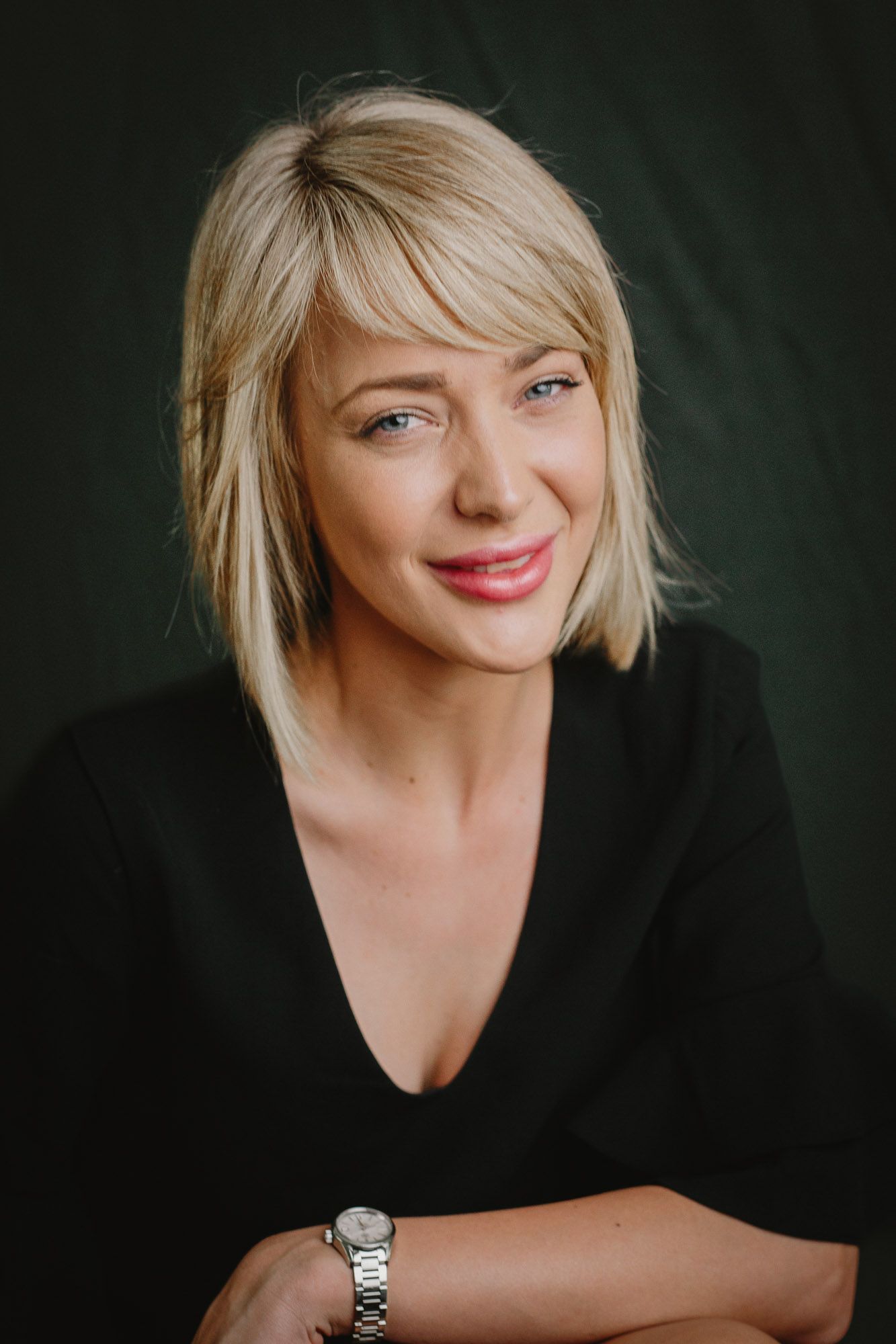 Portrait series of someone with blonde hair wearing black against dark background, showing different angles and expressions.