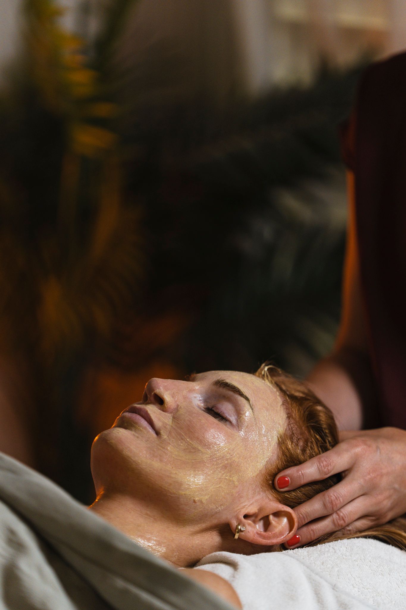 Person receiving a relaxing facial massage treatment at a spa with eyes closed.