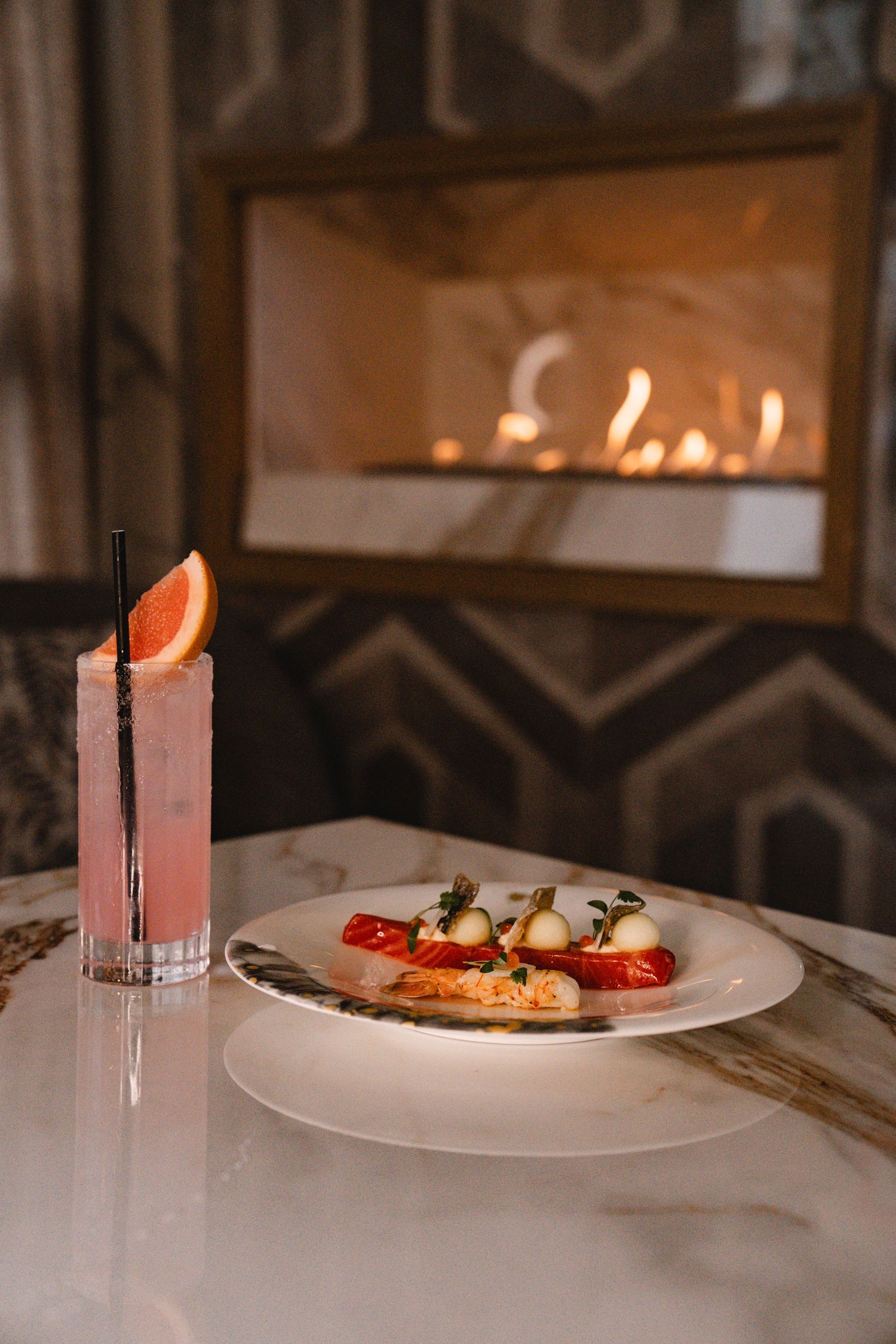 Dimly lit restaurant interior with candles and plated dishes creating an intimate ambiance.