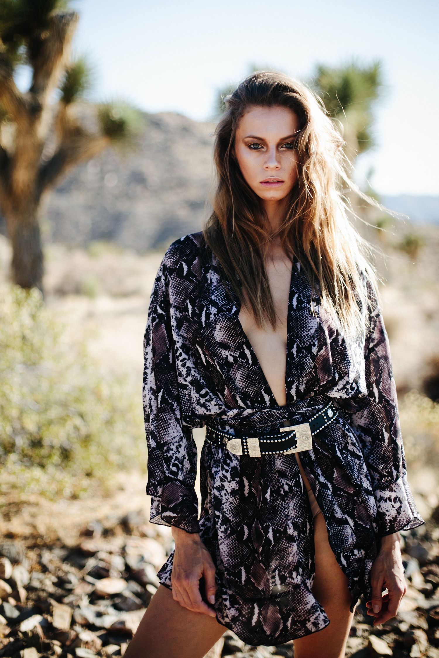 Desert fashion series featuring floral print blouse against Joshua trees and mountains.