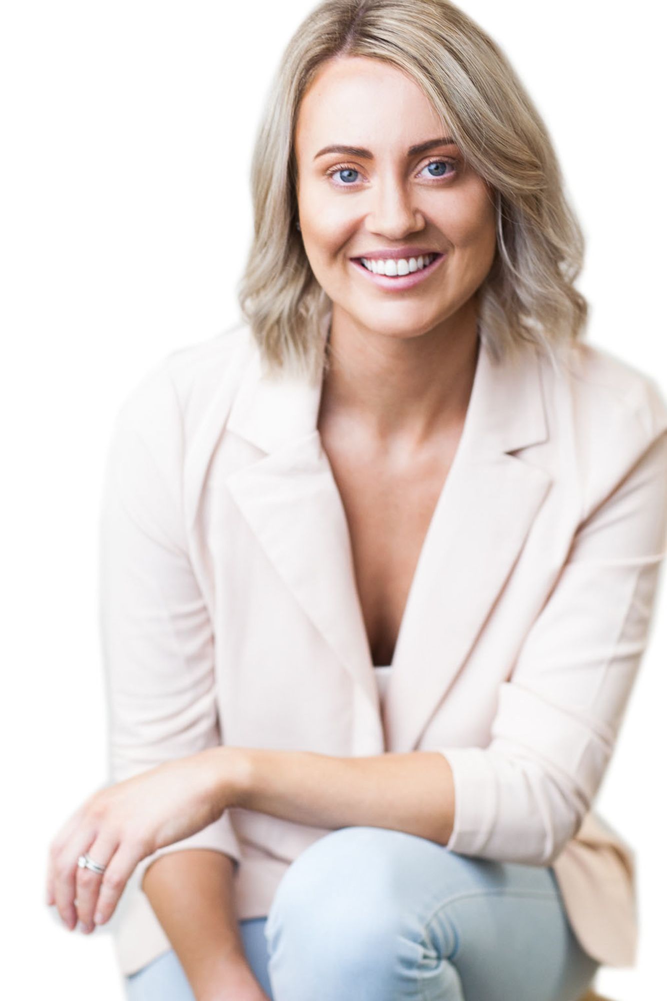 Professional headshot portrait of someone in a cream blazer and light blue jeans against white background.