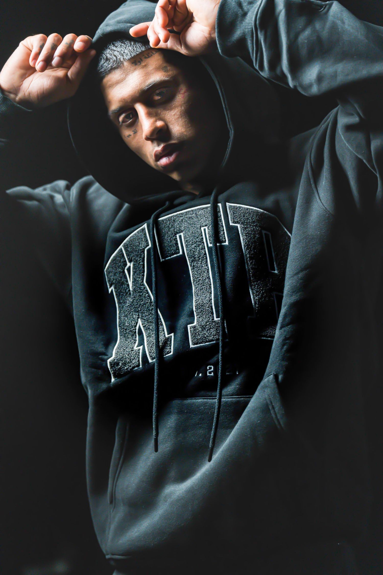 Fashion shots featuring person wearing dark hoodie with graphic text design.