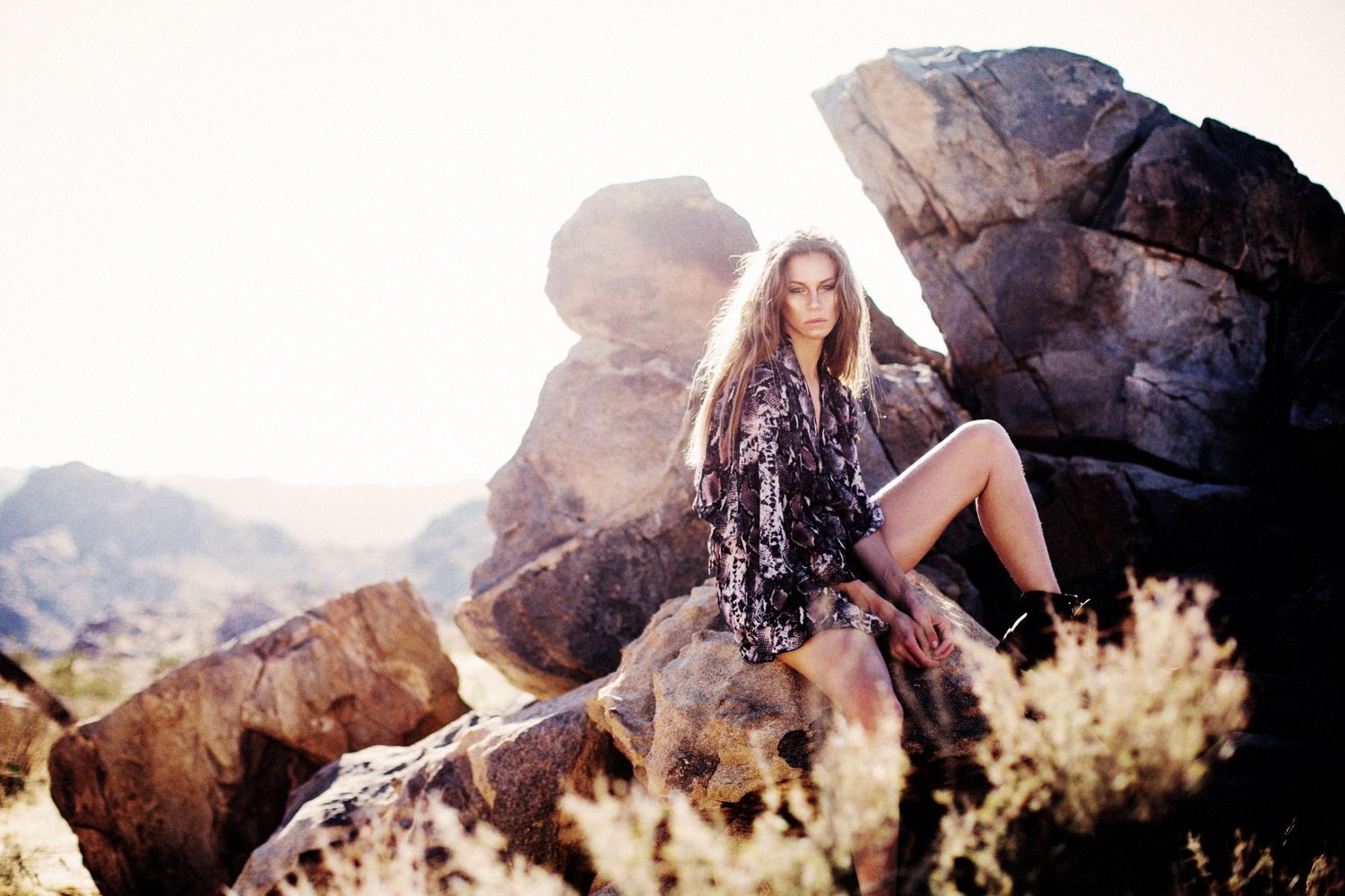 Artistic desert photoshoot with rocky landscape and natural lighting.